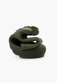 Zoccoli flessibili di colore verde scuro con suola texturizzata, design curvature e un logo discreto di lato. Il materiale sembra simile alla gomma e resistente.