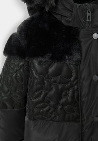 Czarna kurtka puchowa z teksturowanym kołnierzem z sztucznego futra oraz wzorzystym, błyszczącym materiałem z przodu, z matowymi sekcjami i zatrzaskami.