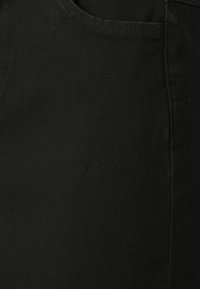 Black denim jeans featuring a smooth texture, classic design, traditional five-pocket styling, and stitched detailing along the seams.
