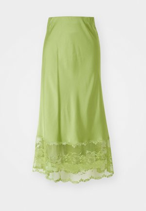 Jupe longue vert citron en tissu lisse. Elle présente une bordure en dentelle au bas, avec des motifs floraux brodés dans la même teinte.
