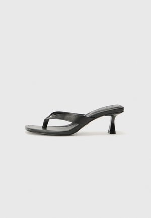 Schwarze Flip-Flop-Sandale mit hohen Absätzen, dünnen Riemen, quadratischem Zehenbereich, glänzender Oberfläche und kleinem Stiletto-Absatz für zusätzlichen Auftrieb.