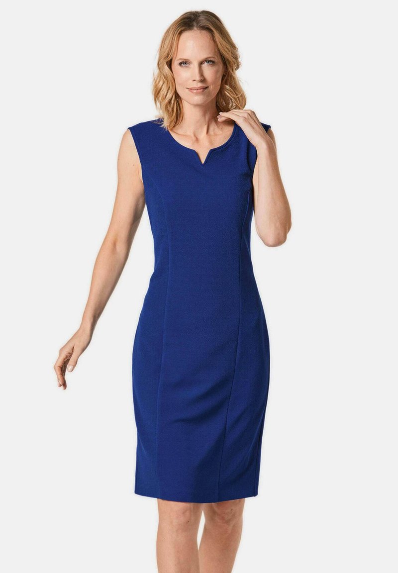 Ärmelloses blaues Kleid mit V-förmigem Ausschnitt, maßgeschneiderter Passform, knieumspielendem Schnitt und strukturierter Oberfläche. Klare Linien, minimalistische Details.