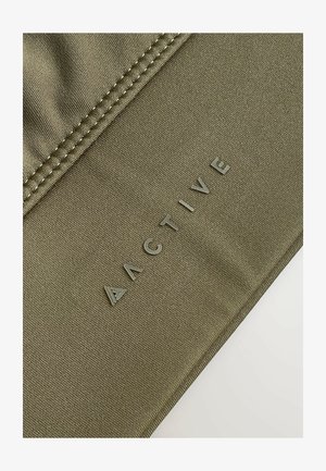 Olivgrüner Sportstoff mit strukturierter Oberfläche. "ACTIVE"-Logo in erhabenen Buchstaben entlang der Naht, neben dekorativen Nähten.