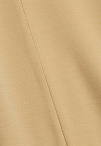 Tissu beige avec un tissage fin et texturé. Présente une couture diagonale et une couleur uniforme sur toute la surface. Surface lisse avec un éclat subtil.