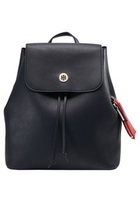 Zaino in pelle blu navy con chiusura a patta e dettagli in metallo dorato. Presenta particolari con coulisse e una tasca con zip rossa. Texture liscia.