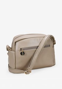 Bolso bandolera de piel beige con un bolsillo frontal con cremallera, correa ajustable y detalles en tono dorado. Textura suave y forma rectangular.