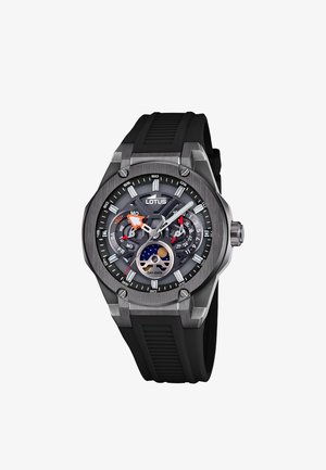 Lotus-kello, jossa on musta kumihihna, harmaa metallikuori, analoginen näyttö, joka sisältää päivän ja päivämäärän indikaattorit sekä kuun vaiheen osoittimen kellotaululla.