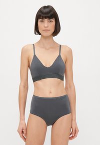 Szürke bralette és magas derekú alsónemű puha anyagból. A bralette vékony pántokkal és alacsony V-nyakkal rendelkezik, texturált pánttal a részletekért.