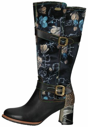 Botte noire en cuir montant jusqu'au genou avec tissu floral bleu et beige, deux sangles décoratives avec boucles dorées et un talon bloc métallique.