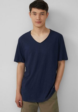 T-shirt bleu marine à manches courtes avec un col en V ; fabriqué en tissu léger avec une texture lisse ; il présente une coupe décontractée et des détails de couture sur les côtés.