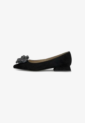 Chaussure plate en suède noir avec un bout pointu, présentant un accent floral texturé noir sur le bout et un petit talon angulaire.