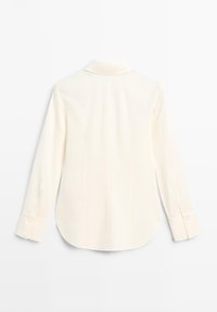 White long-sleeve women's blouse with buttoned cuffs, collar, and curved hem, shown from the back on a plain white background.