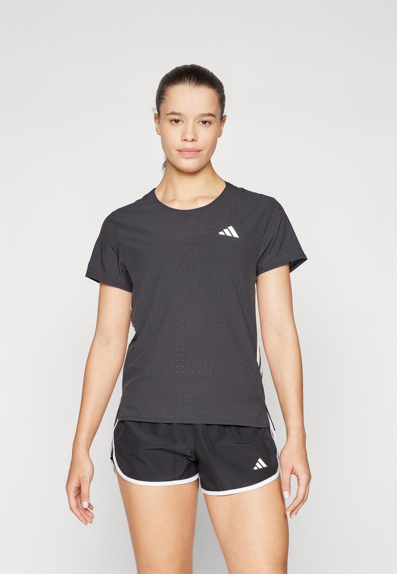 Svart atletisk t-skjorte med korte ermer og perforert tekstur, med en hvit Adidas-logo på brystet. Kombinert med svarte shorts.