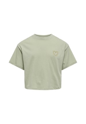 T-shirt court en coton vert clair avec un col rond. Présente un petit design de cœur doré avec des rayons de soleil sur la poitrine gauche.