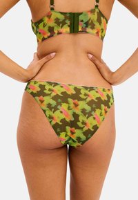 Bikini med blommönster i gröna, rosa och gula nyanser, tillverkat av ett mjukt tyg. Har en figurnära design med justerbara axelband och sömlösa kanter.