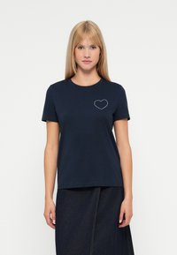 Granatowy T-shirt wykonany z bawełny, z okrągłym dekoltem, krótkimi rękawami oraz wzorem serca z kryształkami po lewej stronie klatki piersiowej.