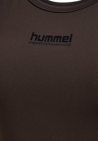 Braunes Sportshirt aus glattem, elastischem Stoff; mit rundem Ausschnitt und subtil geprägtem schwarzen Logo "hummel PERFORMANCE".