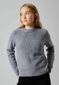 Grau geripptes Sweater aus weichem Stoff; hat einen Rundhalsausschnitt und lange Ärmel; leicht verkürzte Passform mit einem lockeren Schnitt.