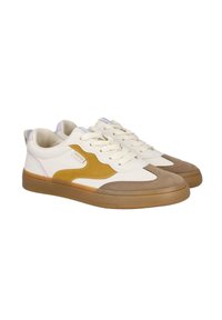 Zapatillas con una parte superior de lona color crema, ante marrón y acentos de piel amarilla. Punta redondeada, suela de goma plana y diseño con cordones.