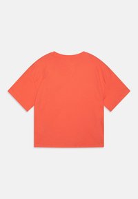Tricou din bumbac cu mânecă scurtă, de culoare corai strălucitoare, având guler rotund, croială lejeră și o textură netedă, fără modele sau accente vizibile.