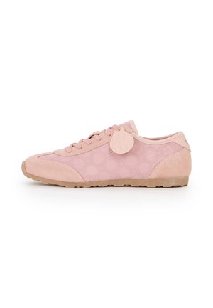 Sneaker bassa rosa con motivo a pois, chiusura con lacci sul davanti, suola in gomma e un'etichetta decorativa rotonda vicino ai lacci su sfondo bianco.