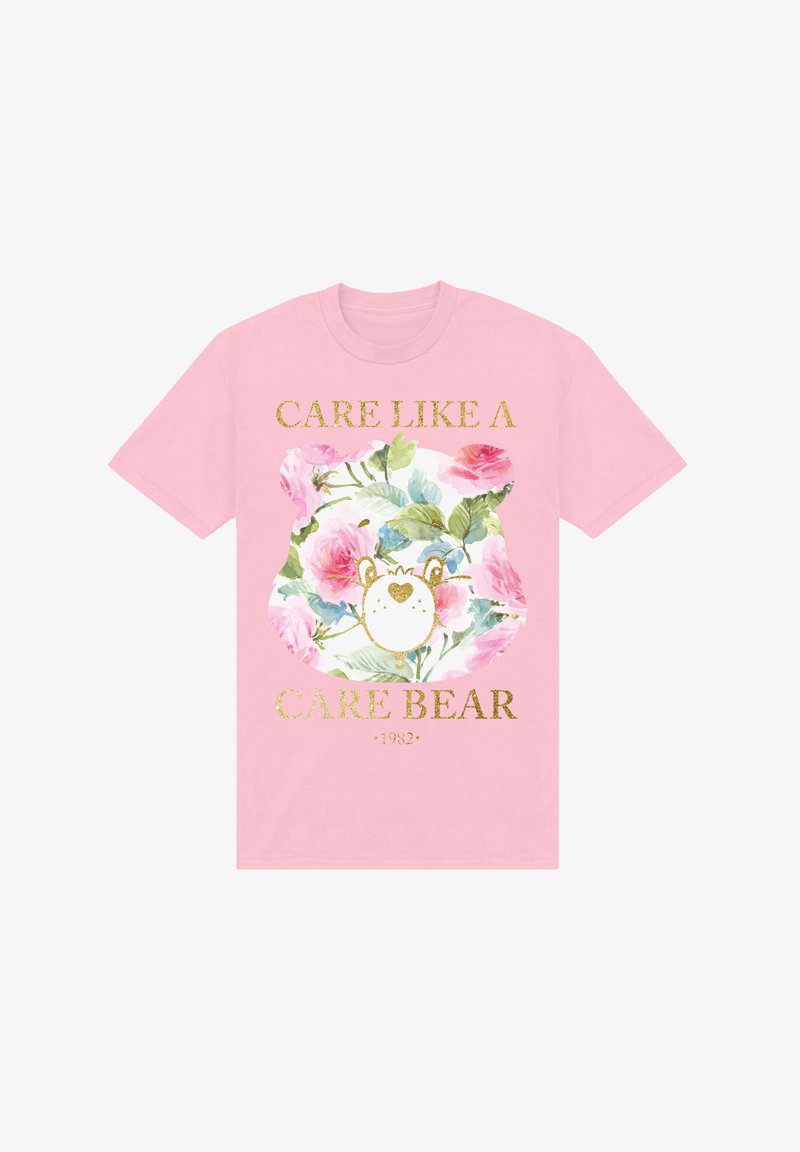 Różowa bawełniana koszulka z motywem kwiatowym, przedstawiająca misia oraz napis "ZAJMUJ SIĘ JAK MISIE ZBAWIAJ 1982" w kolorze złotym. Krótkie rękawy, luźny krój.