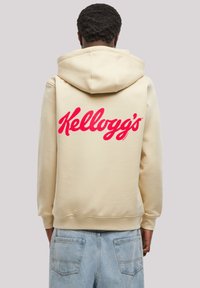 Cream-colored hoodie featuring a large red "Kellogg’s" logo on the back, with a drawstring hood and ribbed cuffs.