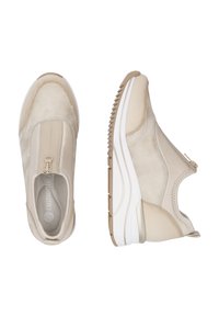 Sneaker beige senza lacci con parte superiore in tessuto testurizzato, suola in gomma con design rigato e un piccolo dettaglio con zip nella parte superiore.