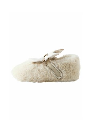 Beige, flauschiger Hausschuh mit einer weichen Textur, runder Form und einer dekorativen Schleife. Verfügt über einen kontrastierenden Riemen an der Seite für zusätzlichen Details.