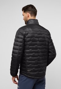Doudoune noire avec un design matelassé horizontal, un col montant et des détails de marquage subtils à la taille et à l'épaule. Texture lisse.