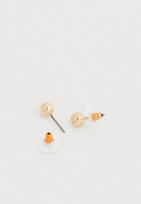 Kullast naastkõrvarõngad, millel on ümmargune kerakujuline disain, läbipaistev tagaosa ja oranž aktsent. Metallil on poleeritud ja tekstureeritud detailid.