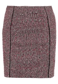 Jupe en tweed arborant un motif rouge, noir et blanc, avec une coupe ajustée et un passepoil noir le long des coutures pour une touche de détail supplémentaire.