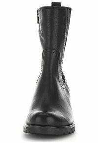 Bota de tobillo de cuero negro con textura suave, puntera redonda, costuras mínimas y cremallera lateral para facilitar el uso. Suela de goma visible en la parte inferior.