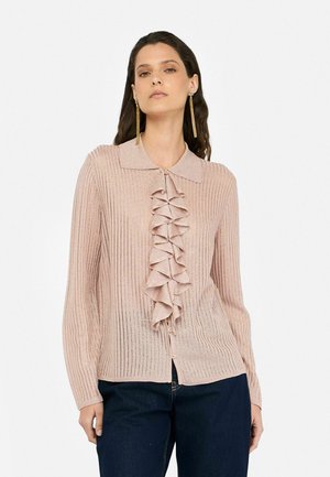 Light pink ribbed cardigan with a ruffled front, long sleeves, and a collared neckline. Features buttons down the front and a textured finish.