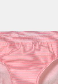Rosa og hvit stripete dametruse laget av myk stoff med elastisk midje og rynkedetaljer på sidene.