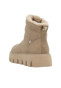 Beige Knöchelstiefel mit weichem Futter, gestepptem Design und dicker Sohle. Verfügt über ein kleines Logo an der Seite und eine abgerundete Zehenpartie.