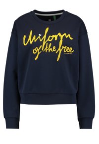 Felpa blu navy con testo ricamato giallo "Uniforme dei liberi". Presenta un collo rotondo e polsini a costine. Tessuto morbido.