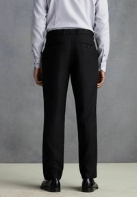 Pantalons de costume noirs en tissu lisse, présentant une coupe droite, deux poches arrière et un fin pli à l'avant.