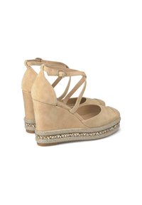 Sandali con zeppa in suede beige, design a cinturino incrociato, punta aperta e decorazioni intrecciate lungo la suola.