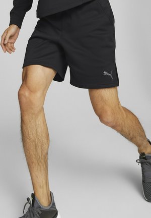 Czarne sportowe szorty z miękkiego materiału, z bocznym rozcięciem dla większej swobody ruchu oraz odblaskowym logo Puma na dolnej części nogawki.