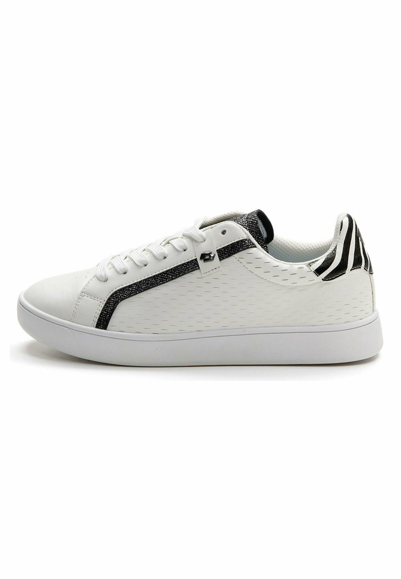 Sneaker bianca con tomaia sintetica testurizzata, striscia brillante nera e scintillante, e tallone a motivo bianco e nero. Presenta una tradizionale chiusura con lacci.