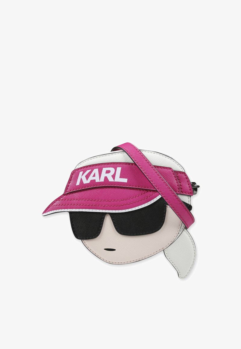 Sac en simili cuir rose et blanc conçu sous la forme d'un personnage de dessin animé portant des lunettes de soleil, avec une bandoulière pour le porter et le logo "KARL" sur la visière.