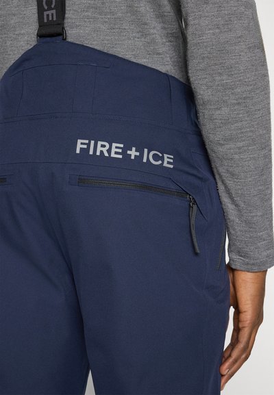Σκούρες μπλε χιονοπαντελόνια με ρυθμιζόμενους ιμάντες, με φερμουάρ στις πλαϊνές τσέπες και το λογότυπο "FIRE+ICE" σε γκρι στο πίσω μέρος. Ανθεκτικό, υφασμάτινο υλικό με υφή.