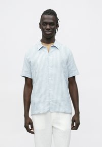 Lichtblauw overhemd met korte mouwen en een geruit motief, met knoopsluiting aan de voorkant en een zachte textuur, gecombineerd met witte linnen broek.