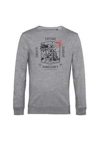 Szara bluza wykonana z mieszanki bawełny, z grafiką inspirowaną Minecraftem, przedstawiającą palmy, wieżę oraz napisy: "TWÓRZ", "BAADAJ", "PRZETRWAJ."