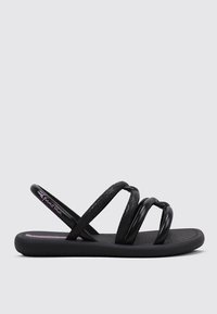Sandalias planas negras con tres tiras texturizadas, una plantilla suave y una suela estampada. Marca visible en rosa en la plantilla.