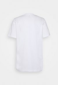 Camiseta blanca de algodón con mangas cortas, escote redondo y un ajuste relajado; textura suave sin patrones o gráficos visibles.