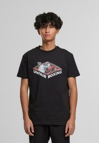 Černé bavlněné tričko s potiskem dvou boxerských rukavic uvnitř diamantového tvaru a textem "NEFEROVÝ BOX" v bílé barvě.