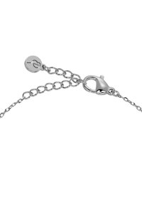 Srebrna bransoletka łańcuchowa z przeplatającymi się ogniwami, zapięciem na karabińczyk oraz okrągłą zawieszką z motywem serca. Gładka, metaliczna faktura.