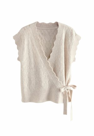 Gilet en maille couleur crème avec des bords festonnés, un col en V, un motif texturé et un détail de lien sur le côté sur fond blanc.
